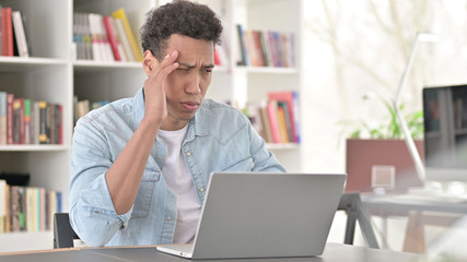 Stressed Young African American Man having Headache at Work