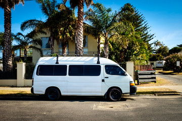 Fototapeta premium A white delivery van parking on the side of the road