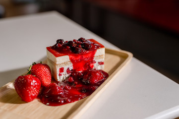 strawberry cake on wooden plate in mini cafe
