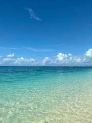 Landscape. A view of the blue ocean from the beach line. Beautiful natural background. Horizon line of the blue sea and sky with clouds. Vertical, cropped picture, free space, nobody.