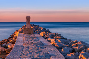 Obraz premium Alba sul mare con obelisco e rocce. Laguna di Grado provincia di gorizia. Italia. Isola del sole.