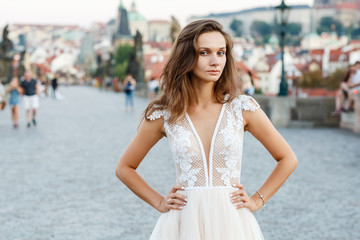 Young bride in a beautiful dress walks on the bridge