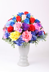 Colorful flower arrangement centerpiece in white ceramic vase