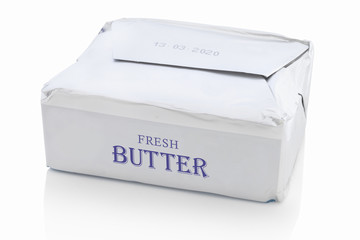 Block of butter from the shop, with fictive logo design. Isolated on white background with shadow reflection. With clipping path. With vector path. Packed piece of butter from supermarket.