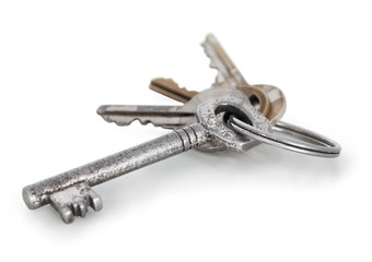 Typical metal bunch of keys from the gate and the house in the village. (Slovakia - Central Europe). Iron standard keys connected with key ring. Isolated on white background with natural shadow.