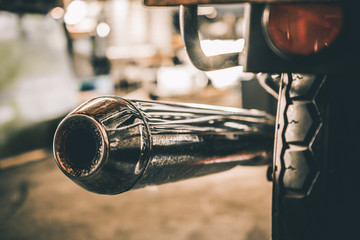 Rear view of classical motorcycle exhaust chrome pipes selective focus.