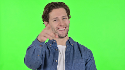 Cheerful Young Man Pointing at the Camera on Green Chroma Key