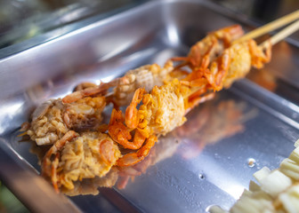 Squids on wooden sticks for grilling.