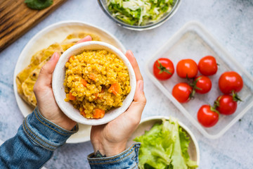 Woman hold in hands basmati Indian vegetables color rice. Yellow traditional biryani. Vegan vegetarian healthy diet
