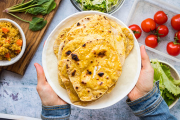 Chapati Indian flatbread. Traditional round bread. Vegan, vegetarian healthy food. Woman hold naan in hands