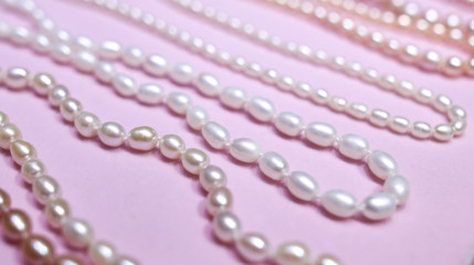 Naklejka na ściany i meble Pearl beads on a pink counter