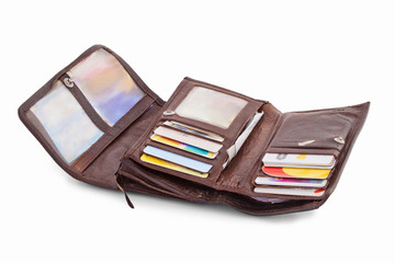 Typical open ladies wallet full of cards, pictures, books of receipts and other things. Isolated on white background with natural shadow. Leather purseful on white bg. Brown skin. Female wallet.