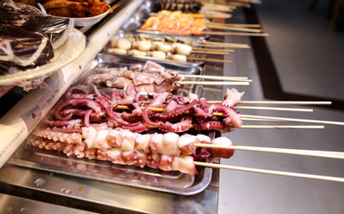 Octopus on wooden sticks for grilling.