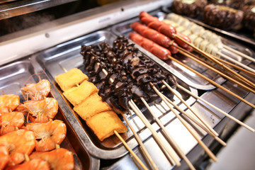 Seafood on wooden sticks for grilling.