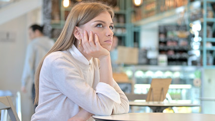 Pensive Young Woman Thinking in Cafe