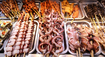 Seafood on wooden sticks for grilling.