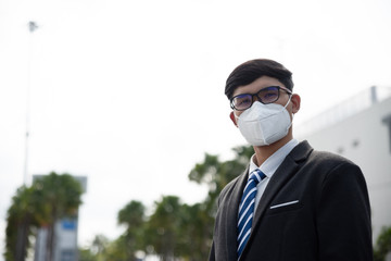 Close up of a businessman in a suit wearing Protective face mask and cough, get ready for Coronavirus and pm 2.5 fighting against in city background.