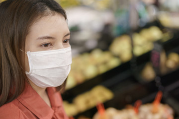 covid-19 spreading outbreak. Woman in medical protective mask panic buying food. Fear of coronavirus.