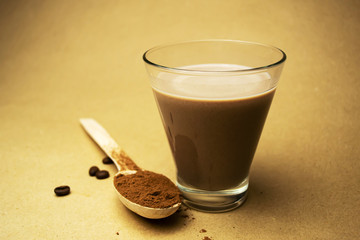  Cocoa milk and a wooden spoon with cocoa powder