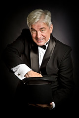 A prestidigitator with a black hat shows tricks