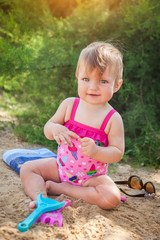 Baby girl playing on beach.