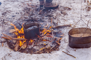 hiking bowler over the fire in the forest in winter