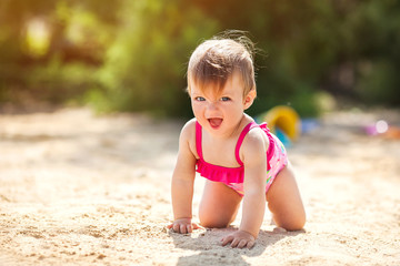 Baby girl playing on beach.