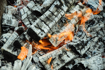 Firewood burning on grill. Texture fire bonfire embers. Smoldering fire