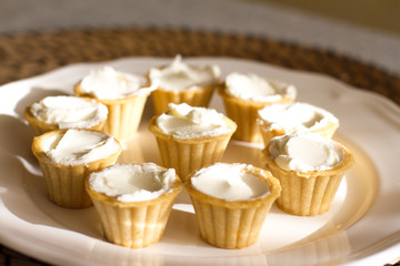 Tartlets with custard or cottage cheese. Empty tartlets or pie on a white table. Food lay flat. The view from the top. The concept of preparing food for the holiday table.