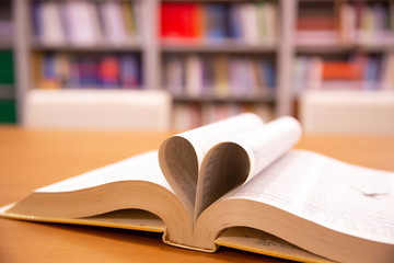 Close up image of a book  in heart shape on the table at library of lifestyle love to read and...