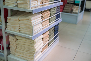 Obraz premium Stacks of colored towels on the shelves in supermarket