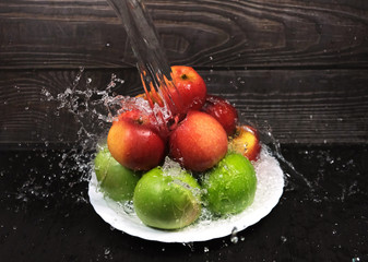 Naklejka premium green and red apples are washed under a powerful stream of water, frozen drops of water,