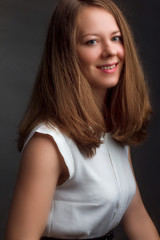 Studio portrait of a blonde in a white blouse on a black background