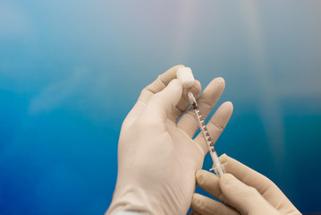 Doctor picking up insulin vaccine in syringe closeup. Diabetes. Sugar as a symbol of diabetes