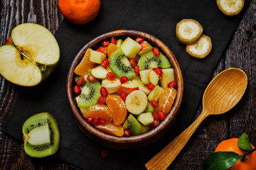 Healthy fruit salad on wood background