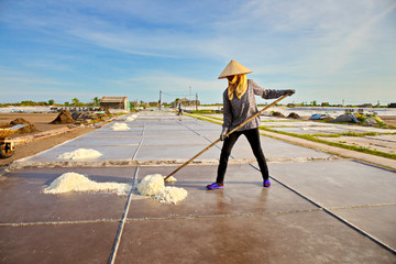 BACH LONG, GIAO THUY, NAMDINH, VIETNAM - JULY 10, 2016: An unidentified local woman working on salt fields. This is one of the biggest salt production locations in Northern Vietnam.