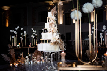 Unusual white tiered wedding cake. wedding decor. 