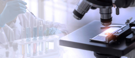 Laboratory concept; close up of microscope with a blurred picture of the scientist is researching in laboratory