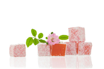 Pink Turkish delight cubes isolated on white background with reflection.