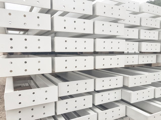 White colored metal girders. Stacked metal parts of a pre-fabricated building