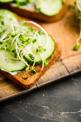Sandwich with cucumber, cheese and microgreens. Selective focus. Shallow depth of field.