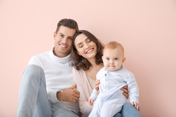 Cute baby with parents on color background