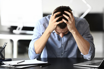 Depressed young businessman in office