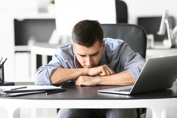 Depressed young businessman in office