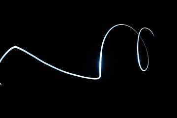 Abstract glowing signing line isolated in black background.