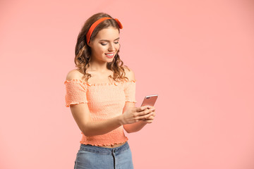 Young woman with mobile phone on color background