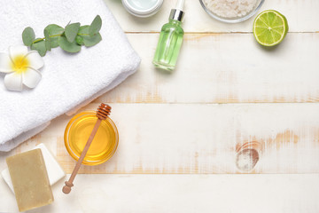 Composition with spa items and honey on white wooden background