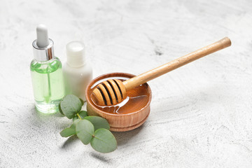 Spa items and honey on light background