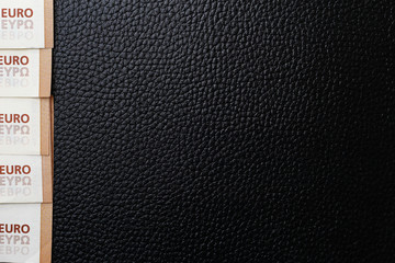 Black leather texture and corners of euro notes, background