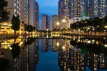 Fototapeta premium Twilight scene of modern city with buildings and reflection on lake in Hanoi, Vietnam